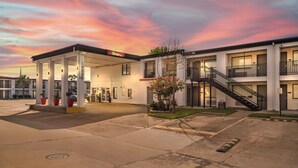 A motel with a gas station, multiple floors, and a staircase leading to the upper levels. - Red Roof Inn Houston – Jersey Village (Houston)