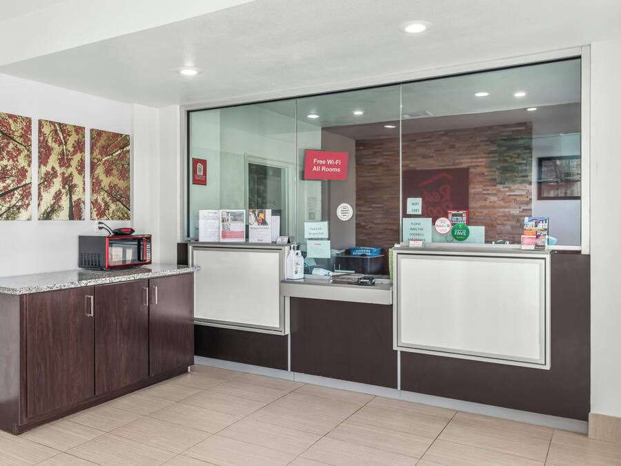 A reception area with a counter, a microwave, and a sign indicating free Wi-Fi in all rooms.