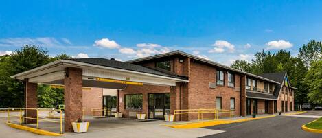 A two-story building with a covered parking area and a brick facade.