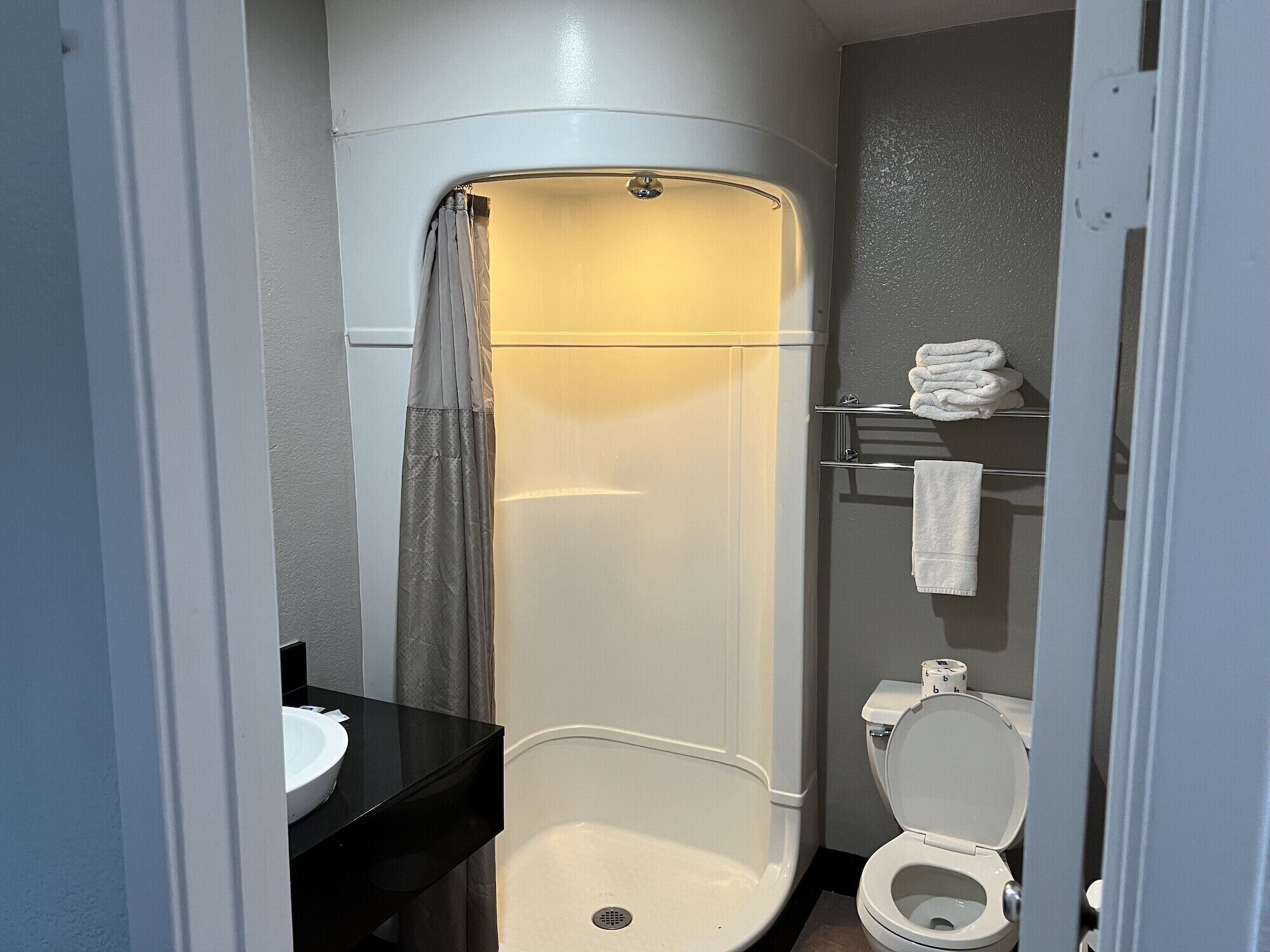 A modern bathroom with a white toilet, a sink, and a shower enclosure.