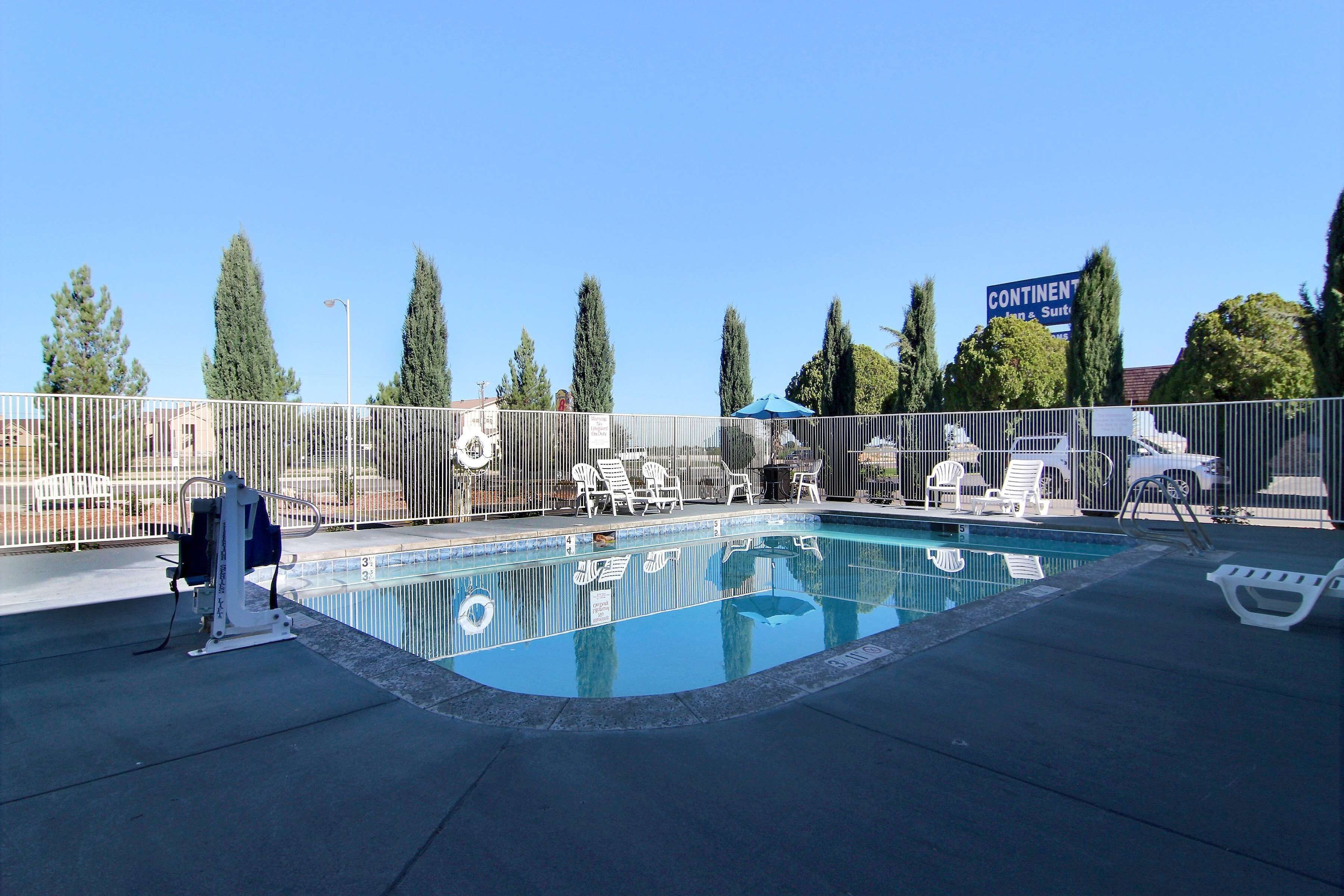 A swimming pool with lounge chairs and a lifeguard stand.