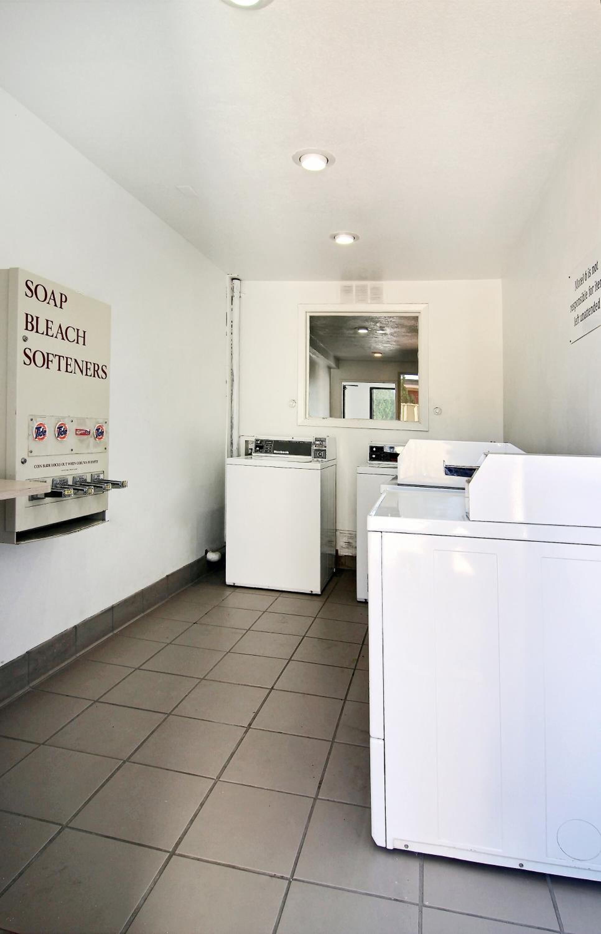 A laundry room with a sign listing soap, bleach, and softeners.