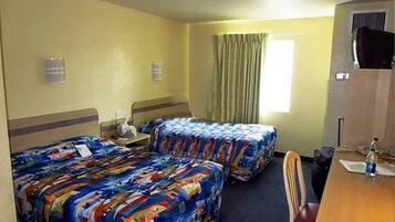 A hotel room with two beds, a desk, a chair, a television, and a window with curtains.