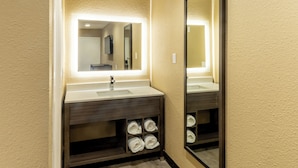 A bathroom with a sink, mirror, and towel storage. - Super 8 by Wyndham Big Spring (Big Spring)