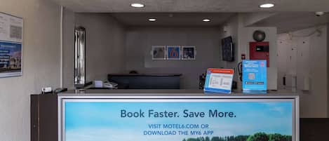 Una mesa de recepción con una pantalla digital mostrando un mensaje de reserva.