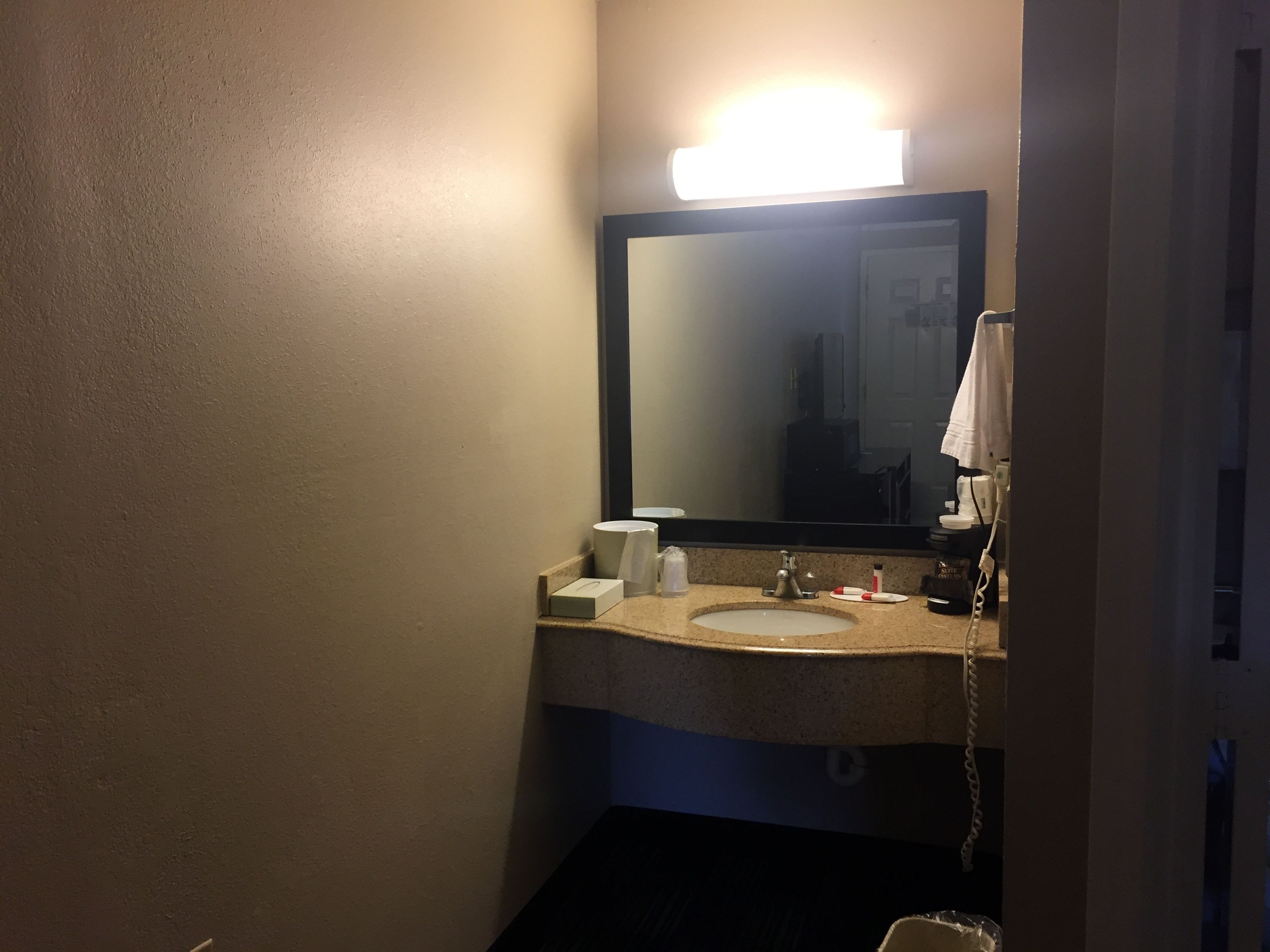 Een badkamer met een wastafel, spiegel en telefoon.