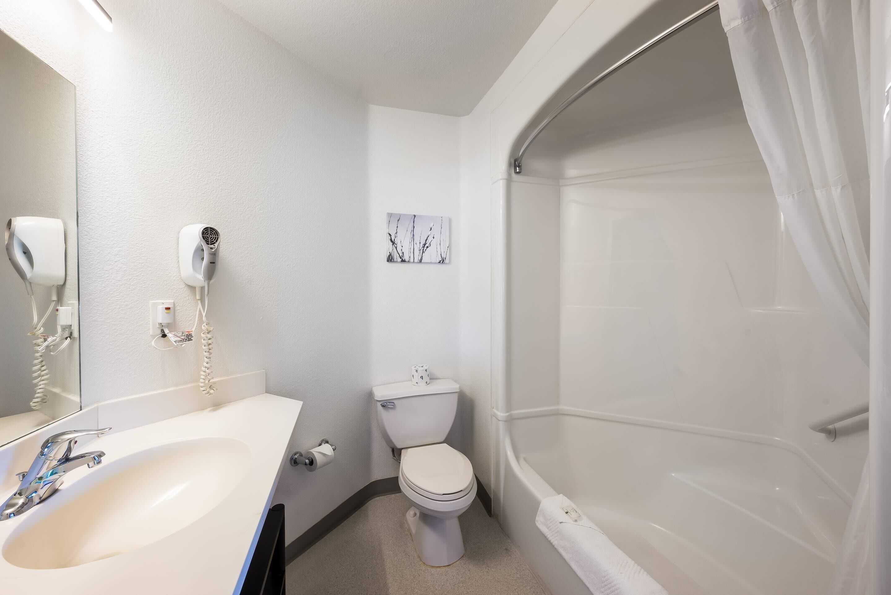 A bathroom with a white sink, toilet, and bathtub.