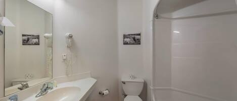 Un baño con lavamanos, espejo, inodoro y bañera.