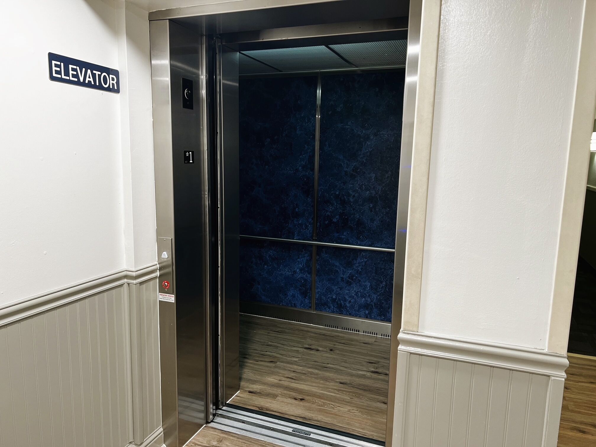 An elevator with a sign indicating its direction.