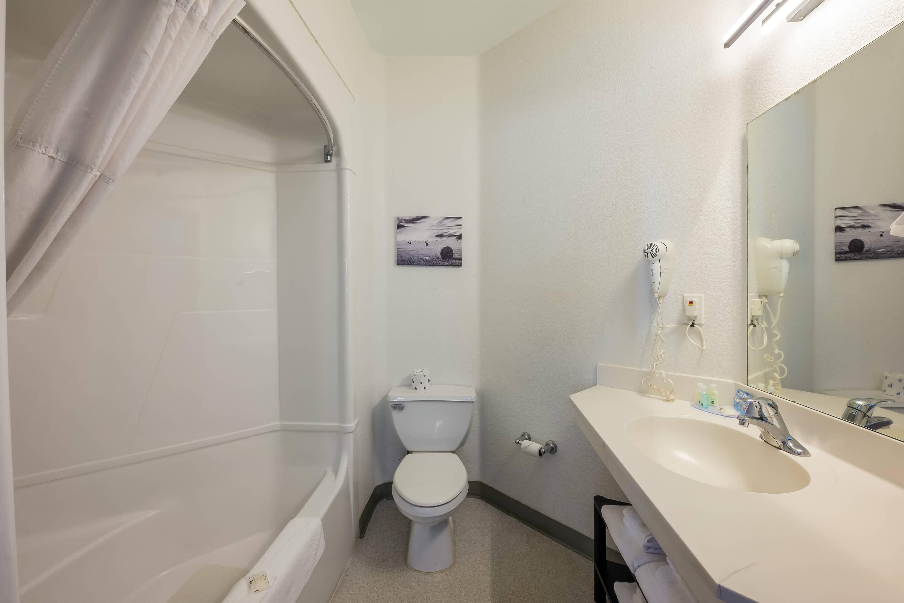 A bathroom with a toilet, sink, and shower.