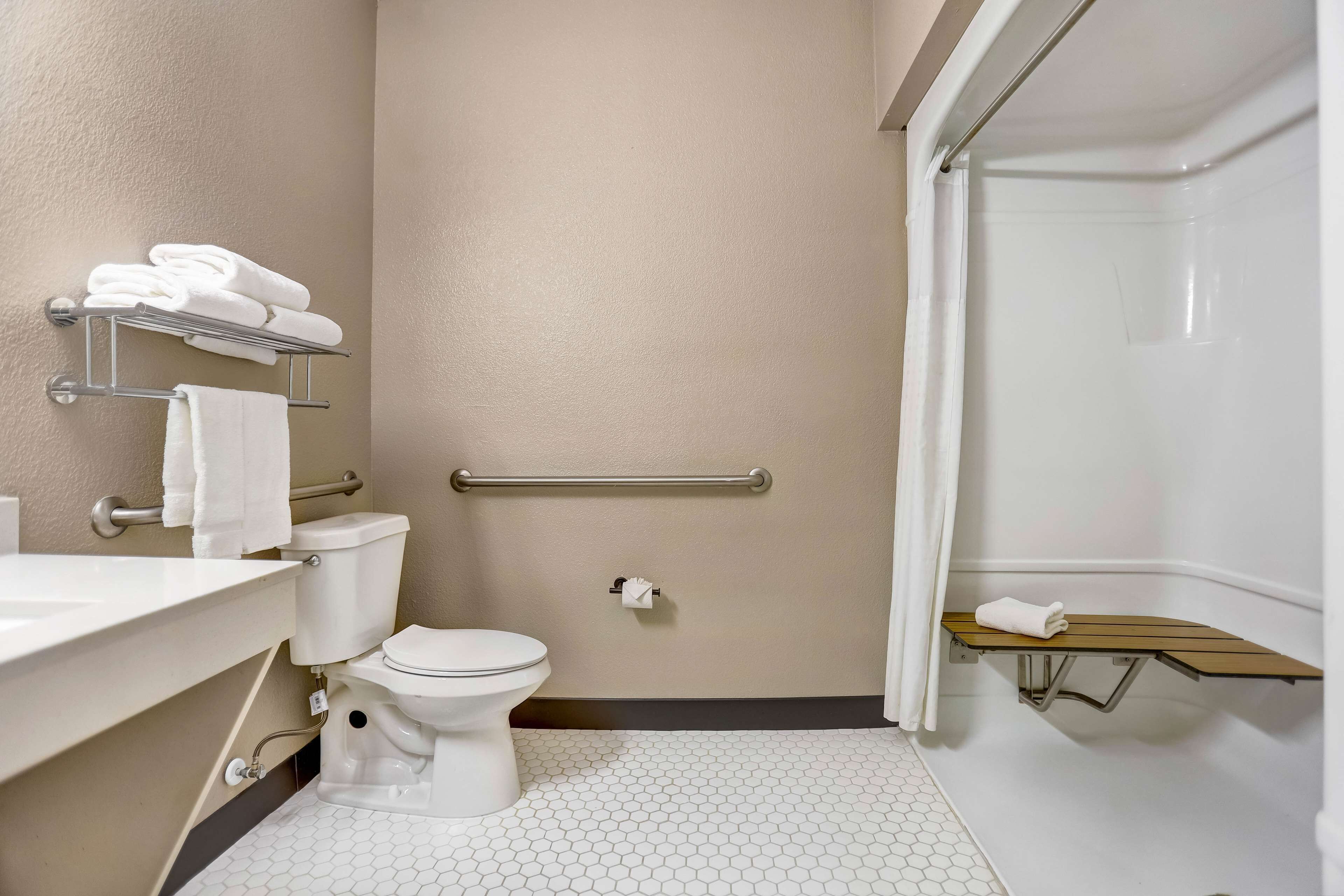 A bathroom with a toilet, sink, and shower area.