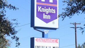 Indicador de Knights Inn amb una fletxa d'entrada i un senyal de parada al fons.