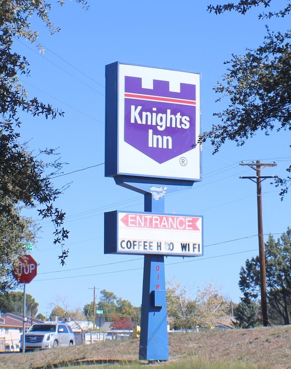 Señal de Knights Inn con una flecha indicando la entrada y una señal de stop al fondo.