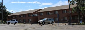 A two-story building with a sign for 'Knights Inn' on the side. There are two parked cars in front of the building.