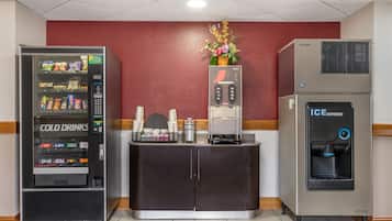 Una màquina expenedora amb l'etiqueta 'COLD DRINKS' i un dispensador de gel a un espai comercial.