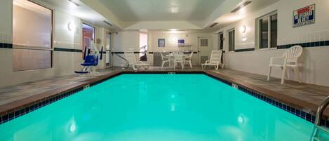 A swimming pool with a tiled deck, a changing room, and a lifeguard station.