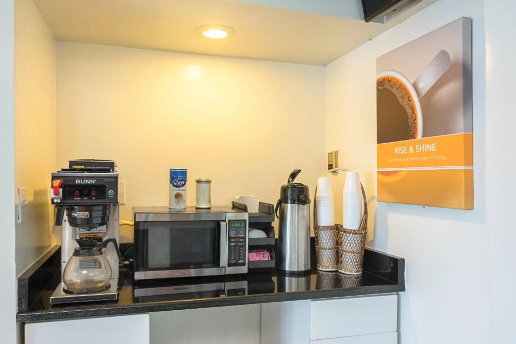 A kitchenette with a Bunn coffee machine, a microwave, a coffee pot, and a coffee maker.