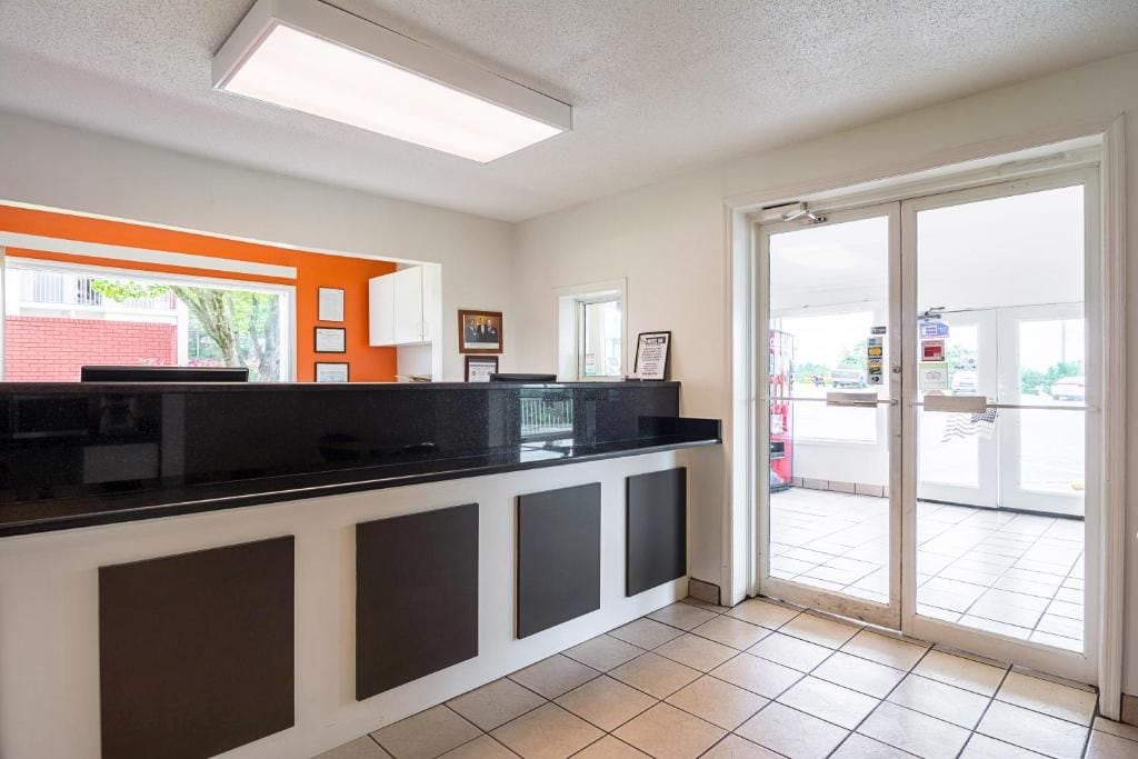 A reception area with a black counter, white cabinets, and a glass door leading outside.
