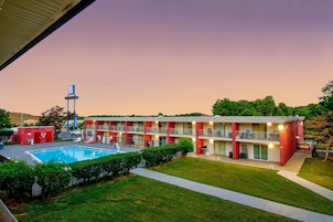 Un motel con piscina, varios balcones y un estacionamiento.