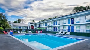 Un motel doté d’une piscine, d’un espace extérieur aménagé et d’une zone clôturée.
