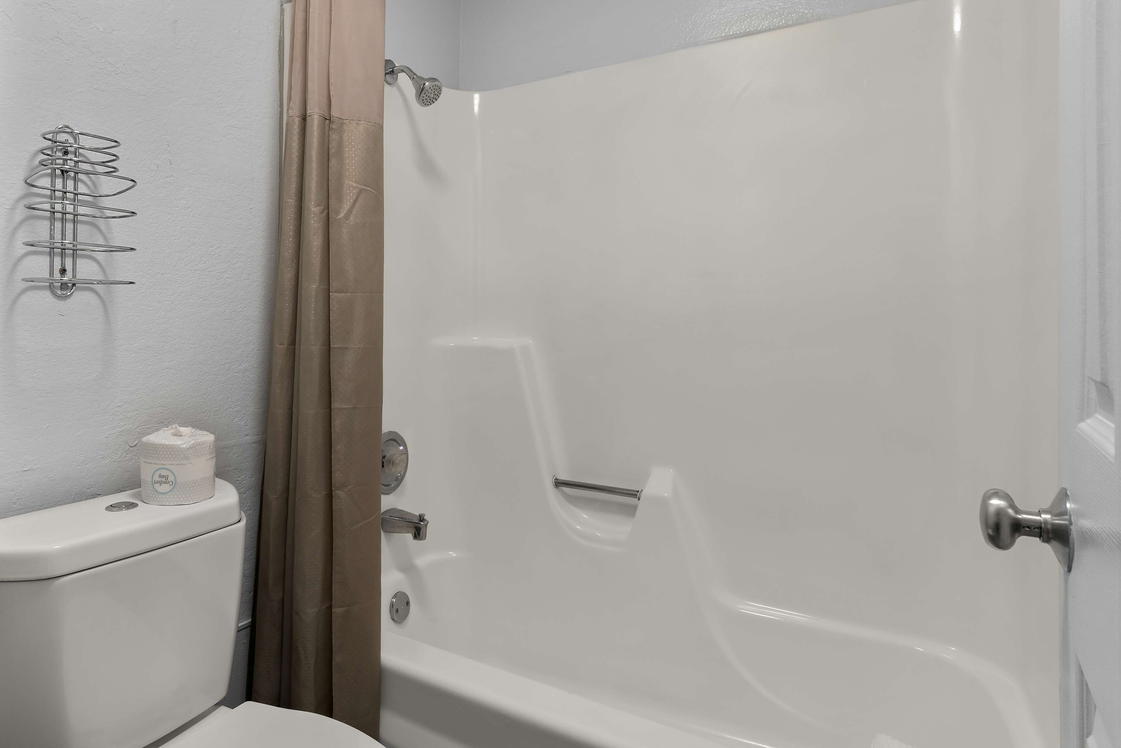 A bathroom with a toilet, a shower, and a towel rack.