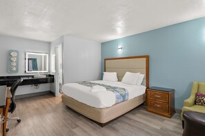 A neatly arranged bedroom with a bed, bedside table, chair, desk, and a mirror. - Americas Best Value Inn Bangor (Bangor)