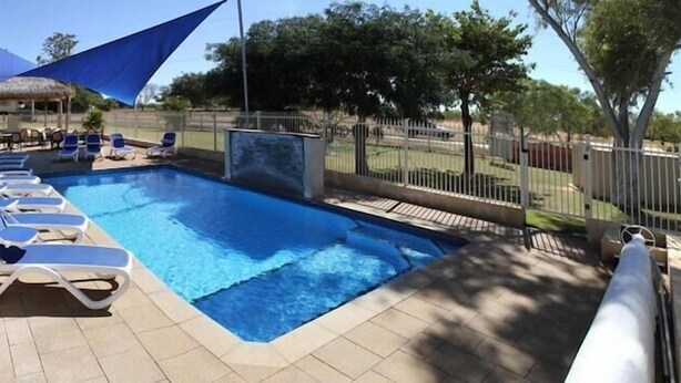 A swimming pool with lounge chairs and a shaded area. - Best Western Halls Creek Motel (Halls Creek)