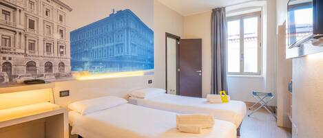 A hotel room with two beds, a desk, a chair, a TV, a window with curtains, and a wall mural.