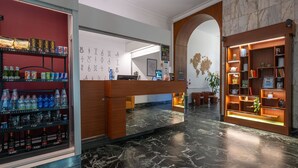 A hotel lobby with a reception desk, a water bottle display, and a world map decoration. - B&B Hotel Trieste (Trieste)