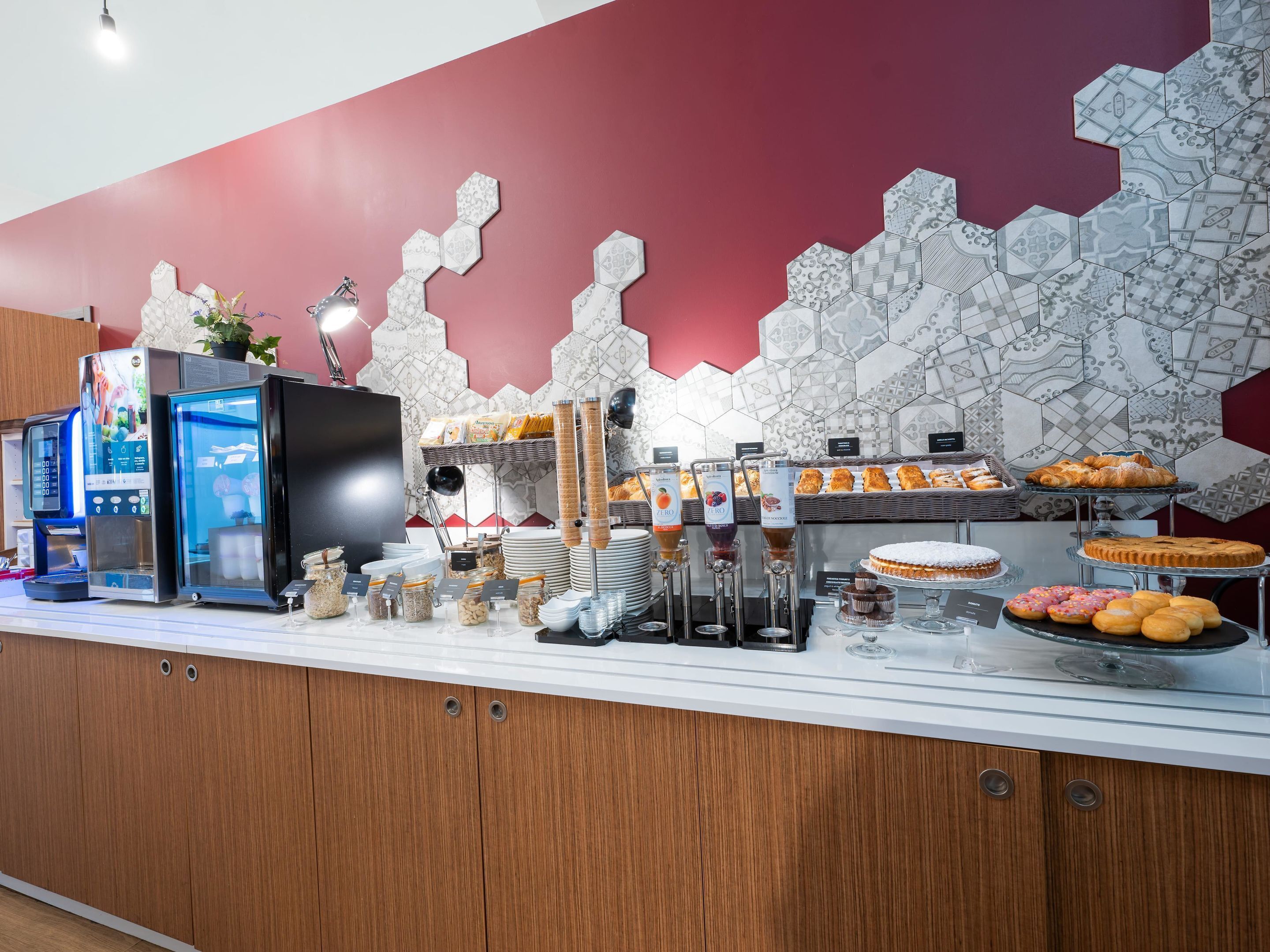 A breakfast buffet with various food items, a coffee machine, and a juice dispenser.
