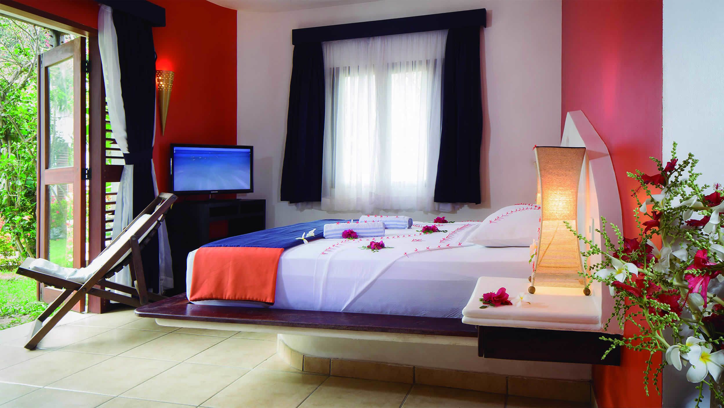 Une chambre d’hôtel avec un lit, une télévision, un bureau et une chaise.