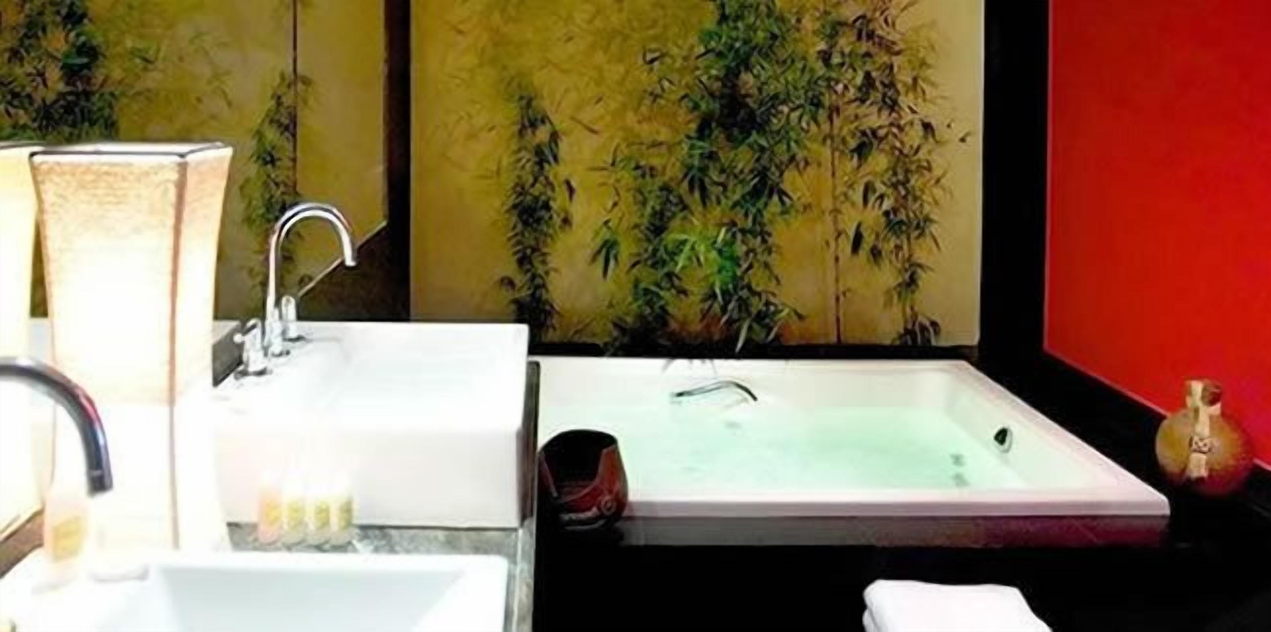 Un baño con bañera, lavabo y espejo.