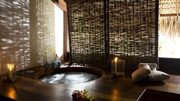 A spa area with a hot tub, candles, and towels. - My Blue Hotel (Jijoca de Jericoacoara)