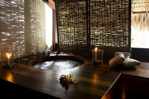 A spa area with a hot tub, candles, and towels. - My Blue Hotel (Jijoca de Jericoacoara)