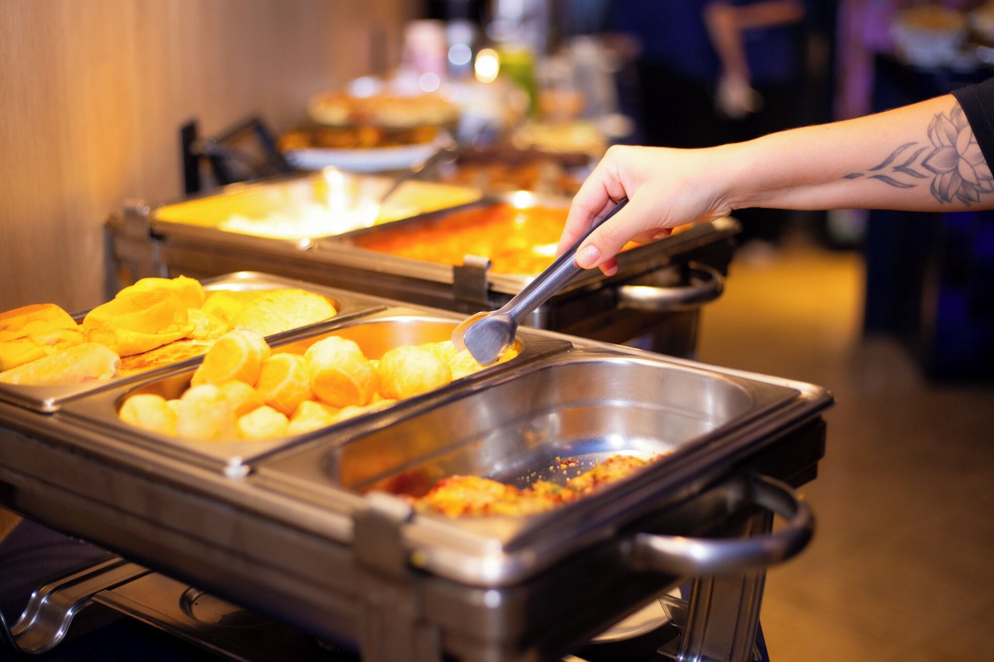 A buffet with various food items, including what appears to be fried items and a dish with a red sauce.
