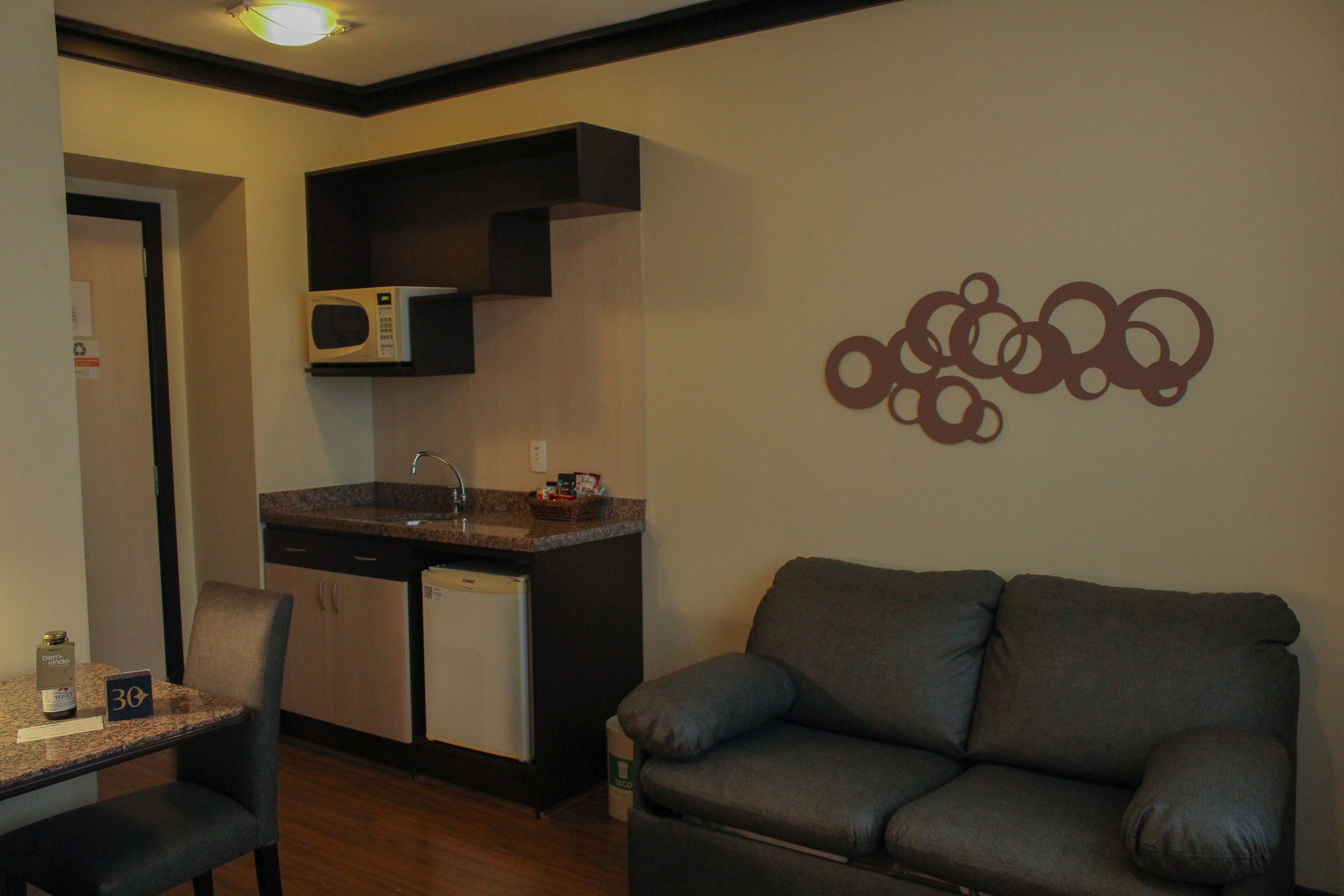 A compact living space with a kitchenette, a sofa, and a dining area.
