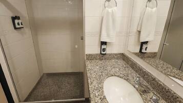 A bathroom with a shower, a sink, and a mirror.