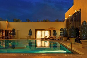 Una piscina al aire libre, sillones reclinables de piscina