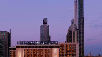 A Sheraton hotel with a modern facade, multiple floors, and illuminated signage.