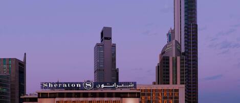 Un hôtel Sheraton doté d’une façade moderne, de plusieurs étages et d’une enseigne lumineuse.