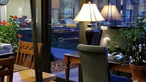 Un comedor con una mesa, sillas y vistas de la ciudad a través de ventanas amplias.