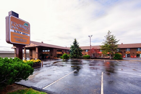 A Foothills Inn with a sign advertising outdoor pool, continental breakfast, and sleep great.