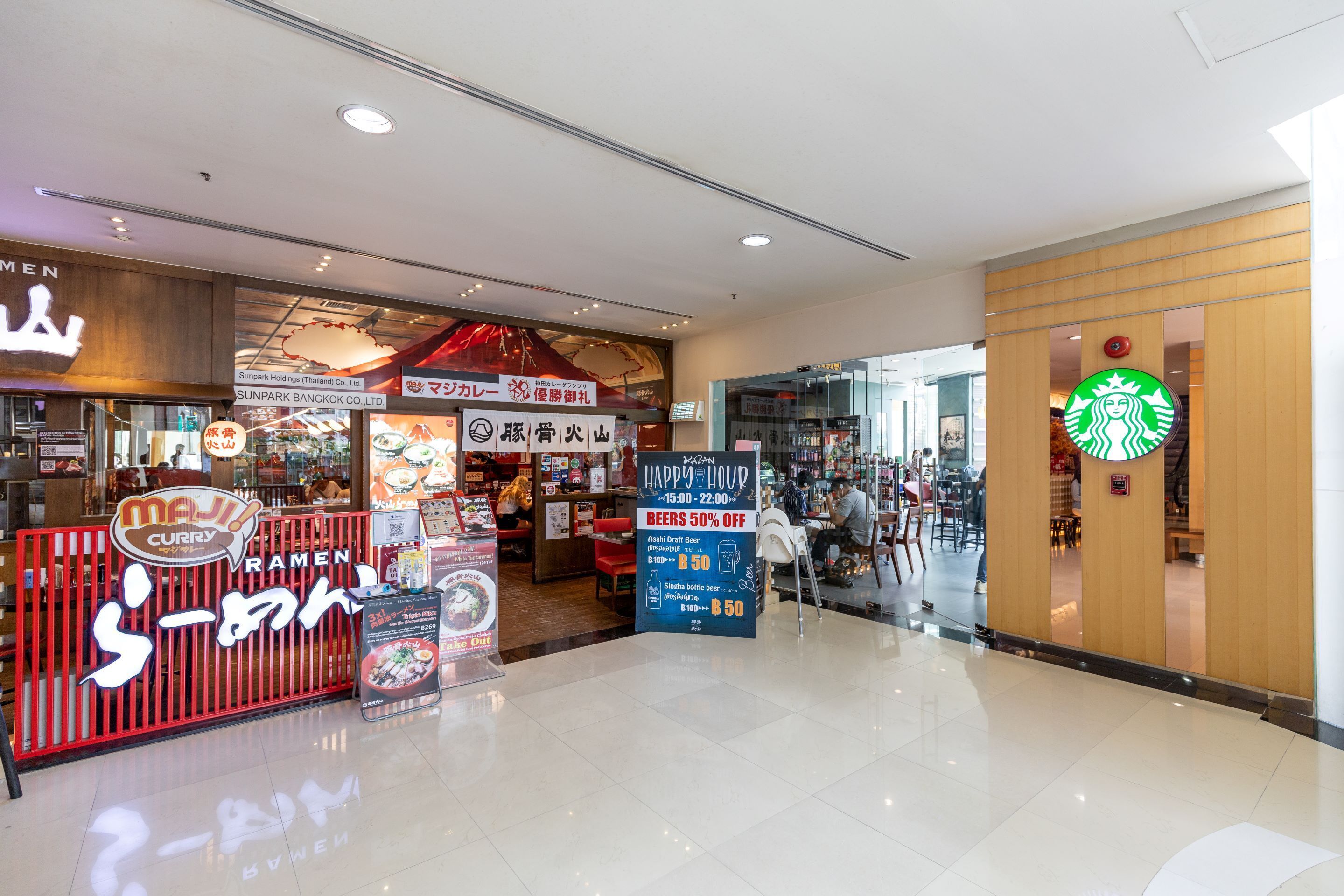 A food court with various eateries, including a curry ramen restaurant and a Starbucks.