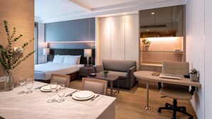 Une chambre d’hôtel moderne équipée d’un lit, d’un canapé, d’un bureau et d’un coin repas.