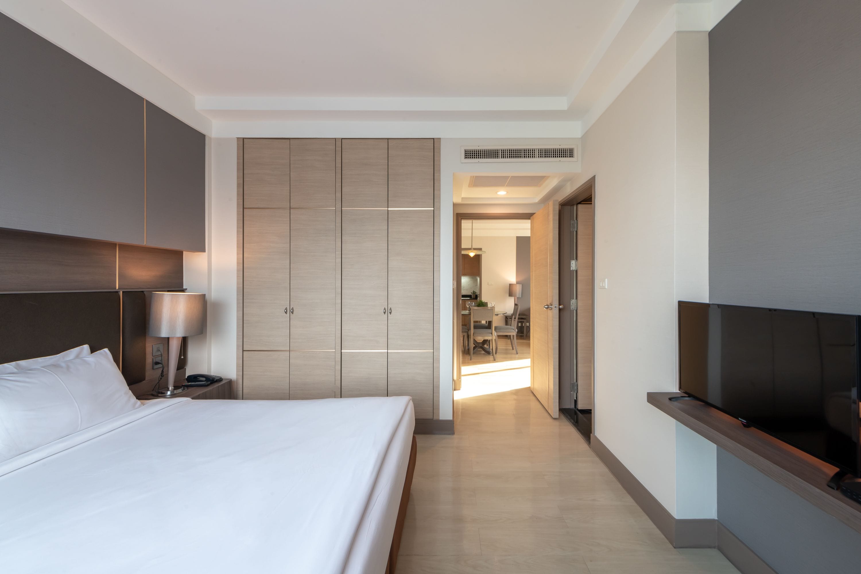 Ein Hotelzimmer mit einem großen Bett, einem Schreibtisch, einem Fernseher und einem Kleiderschrank.