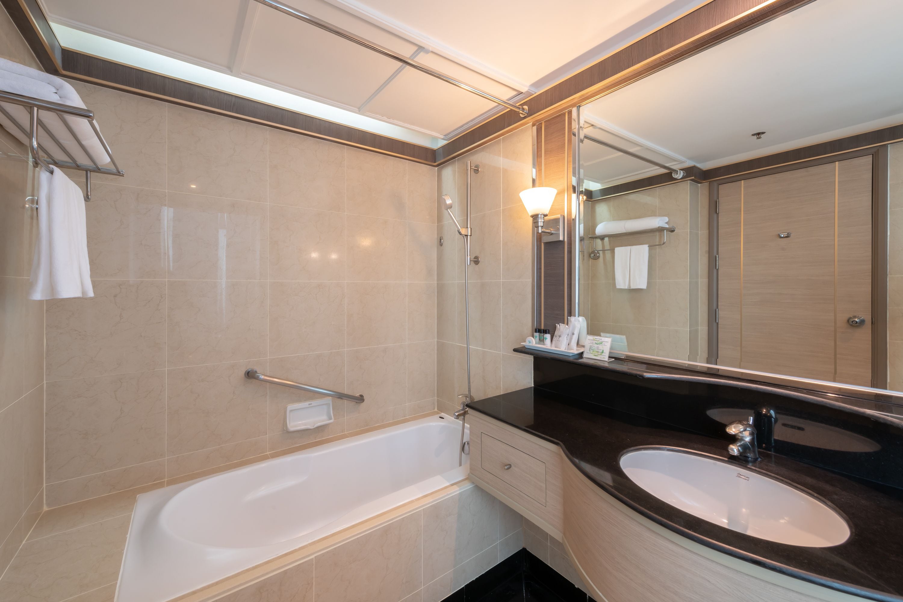 A modern bathroom with a bathtub, a sink, and a large mirror.