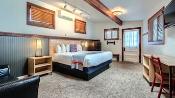 Ein Schlafzimmer mit Bett, Nachttischen, einem Schreibtisch und einem Sessel.