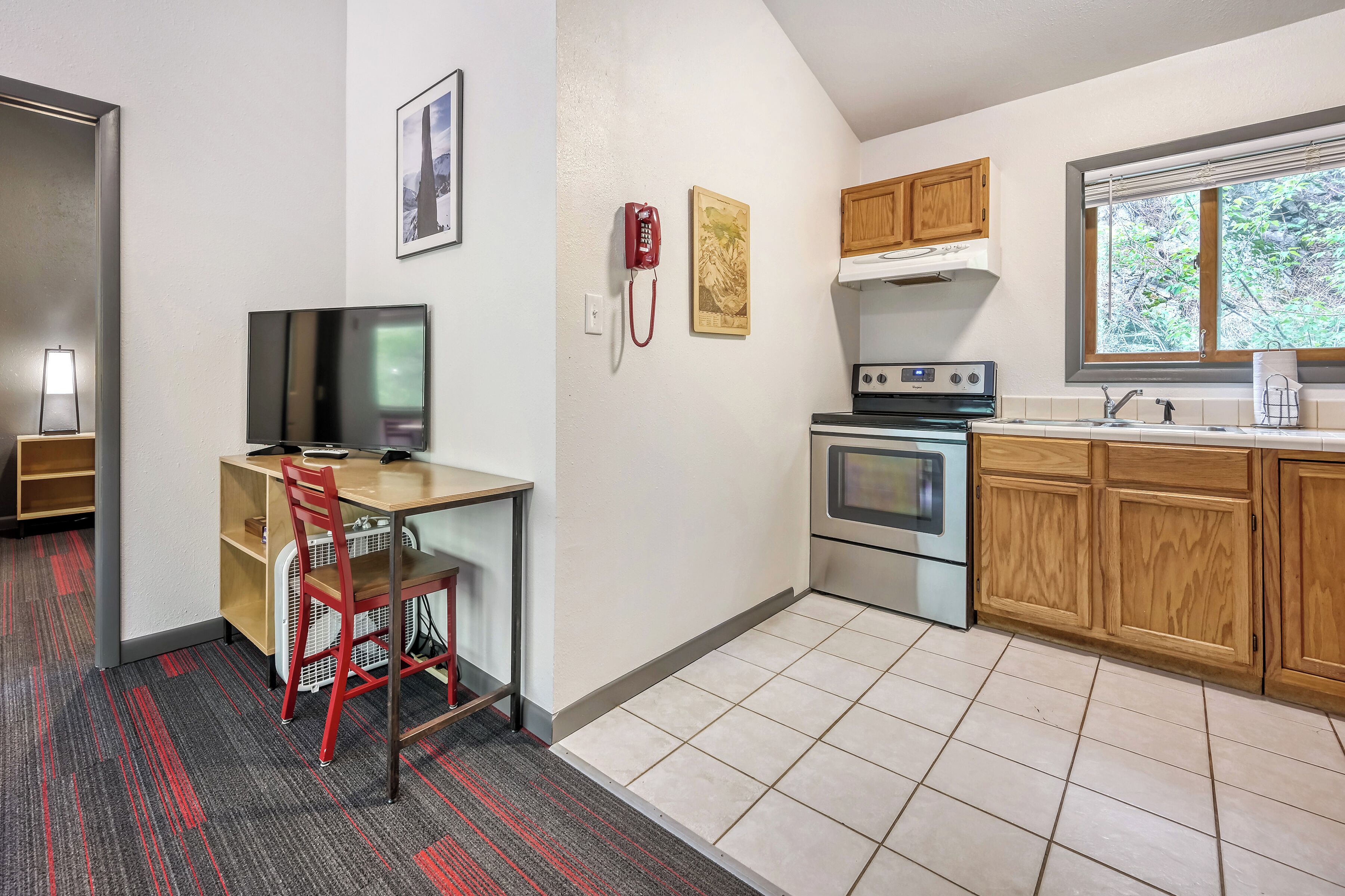A compact kitchen with a stove, oven, and wooden cabinets.