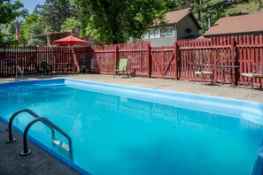 Una piscina al aire libre de temporada, sombrillas