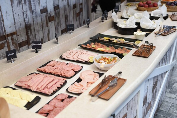 A buffet with various meats and condiments.